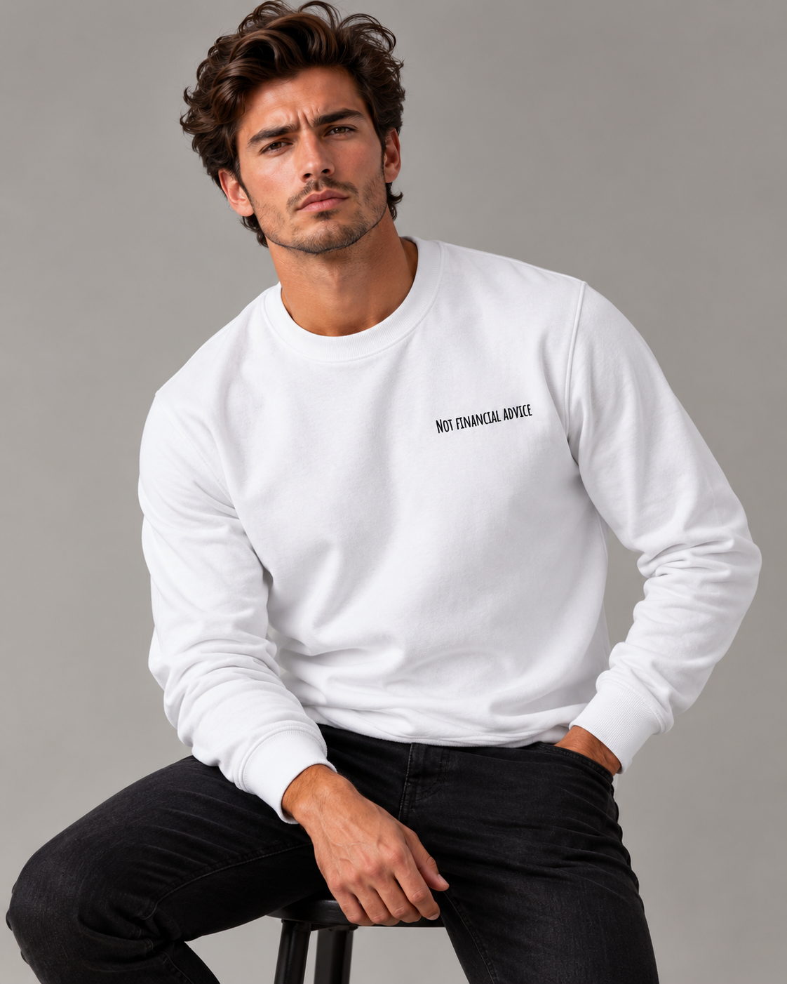 Male studio portrait wearing the White Not Financial Advice sweatshirt with black embroidery